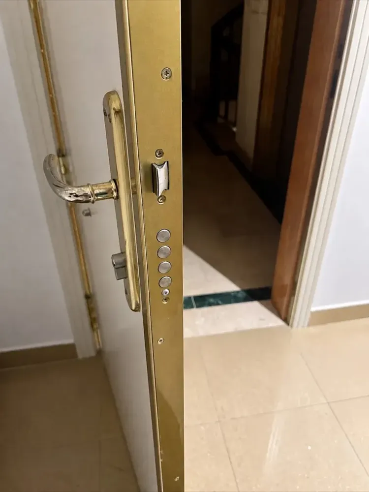 Cerradura multipunto de cuatro bulones con frente dorado en puerta blindada