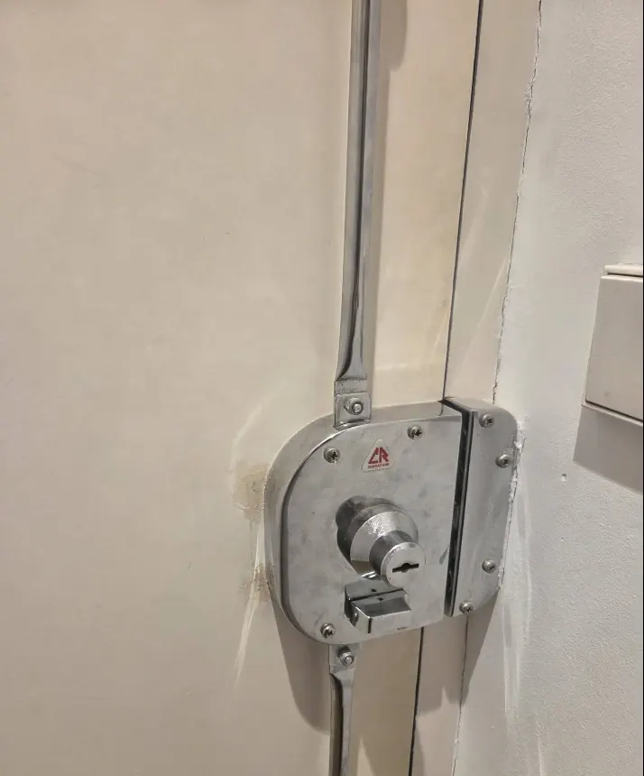 Cerradura de sobreponer con barras verticales en puerta de piso