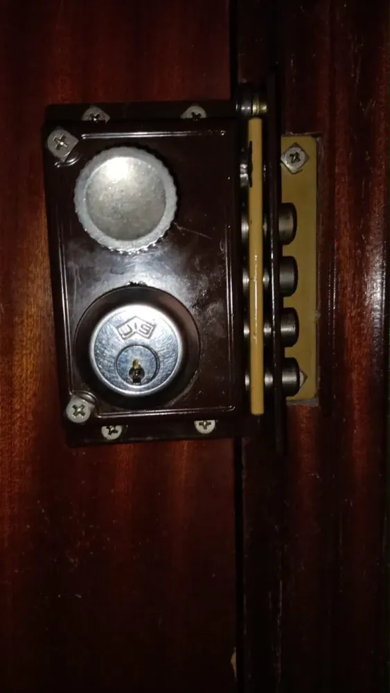 Cerradura de sobreponer con bulones en puerta de madera