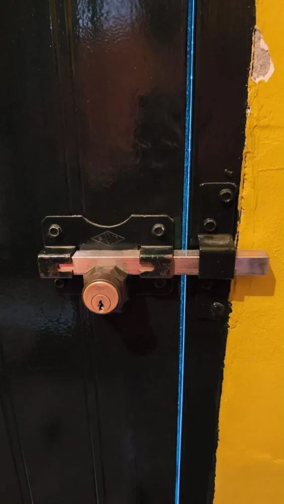Cerrojo de seguridad con bombín instalado en puerta de madera