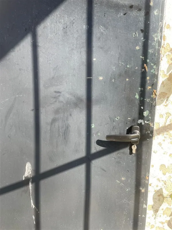 Puerta metálica con manilla y bombín cambiados