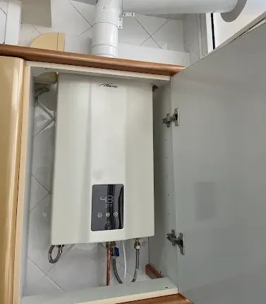 Calentador de gas nuevo instalado dentro de mueble de cocina