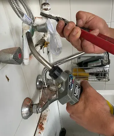 Fontanero reparando un grifo de bañera
